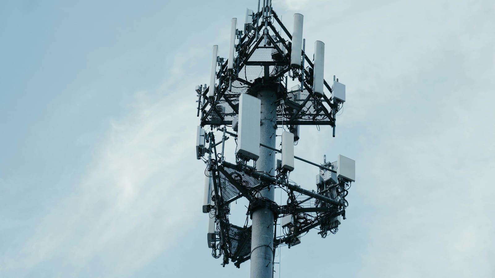 SKT와 KT의 하이퍼 AI 네트워크 실증을 상징하는 5G 통신 안테나와 도시 네트워크 이미지