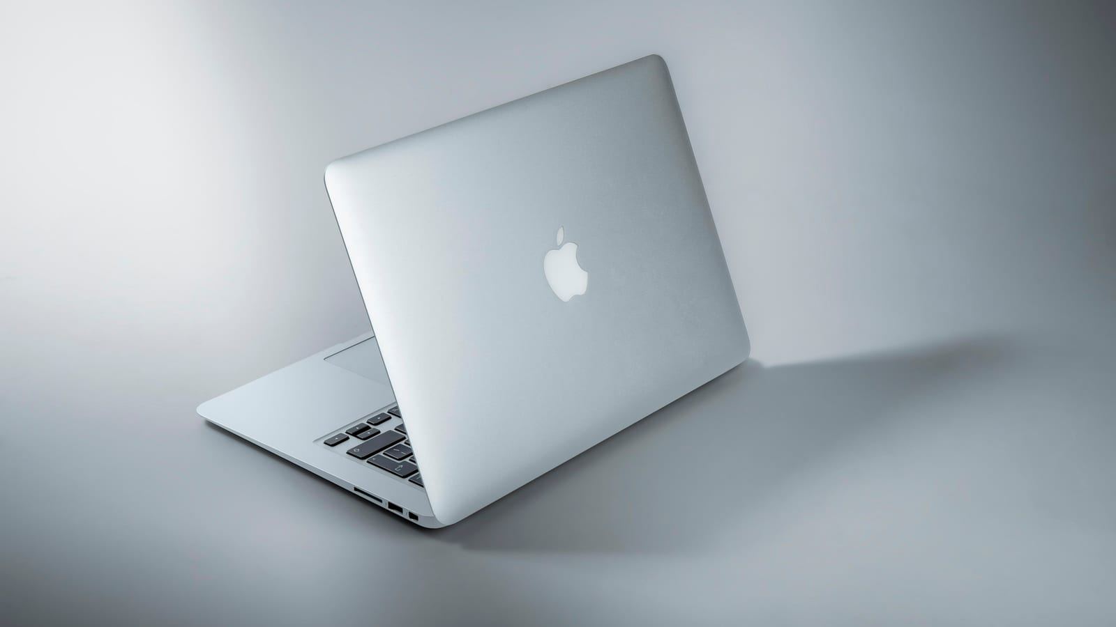 애플 WWDC26과 AI 소프트웨어 업데이트를 떠올리게 하는 노트북과 스마트폰 작업 공간